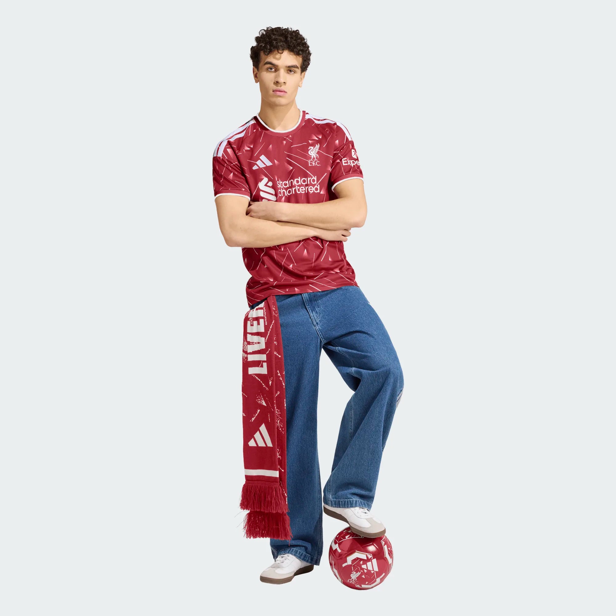 Person wearing a Liverpool football club jersey and scarf on a white background
