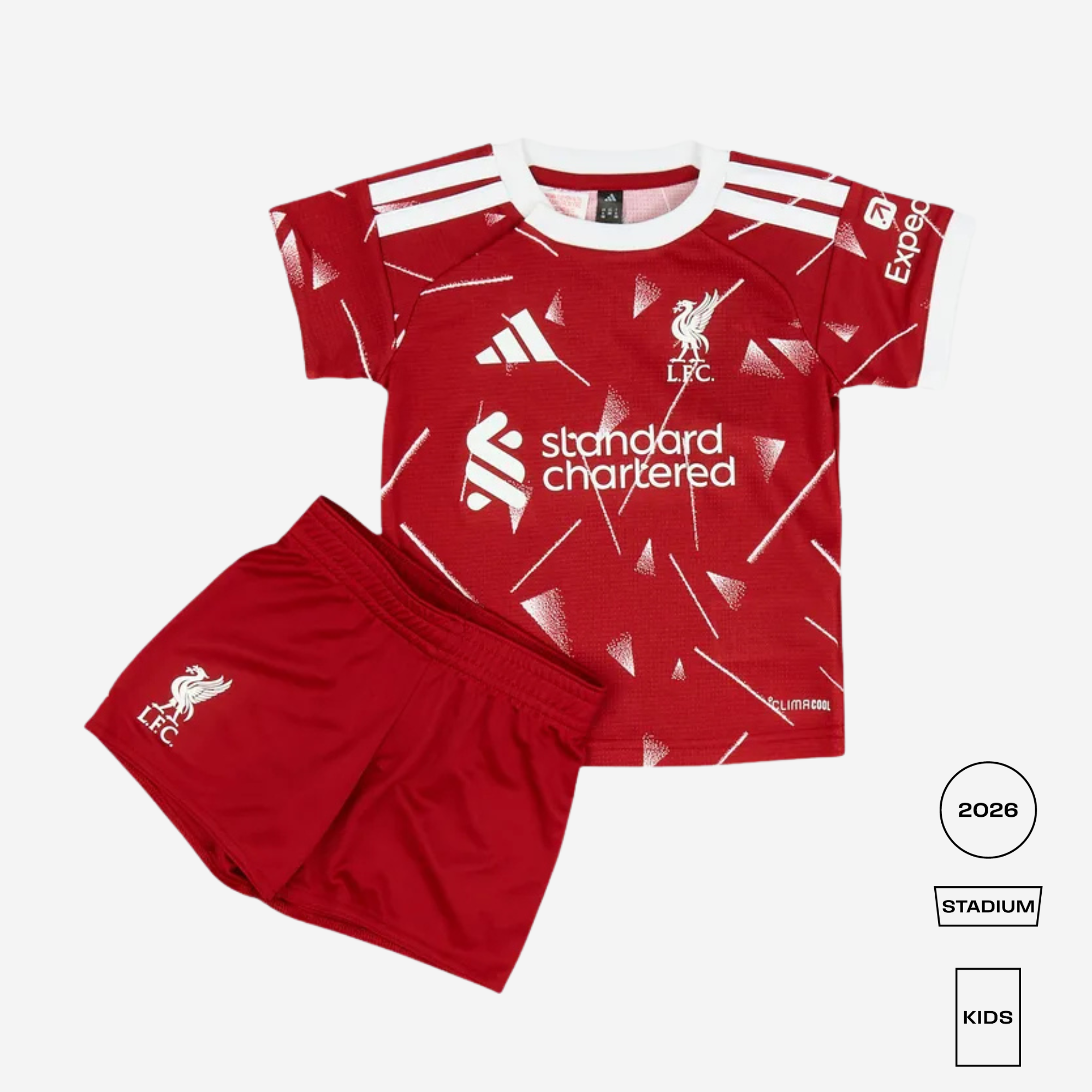 A kids' red and white Adidas Liverpool football kit featuring a short-sleeve jersey and matching shorts, displayed on a light gray background with 2026 Stadium Kids edition badges.