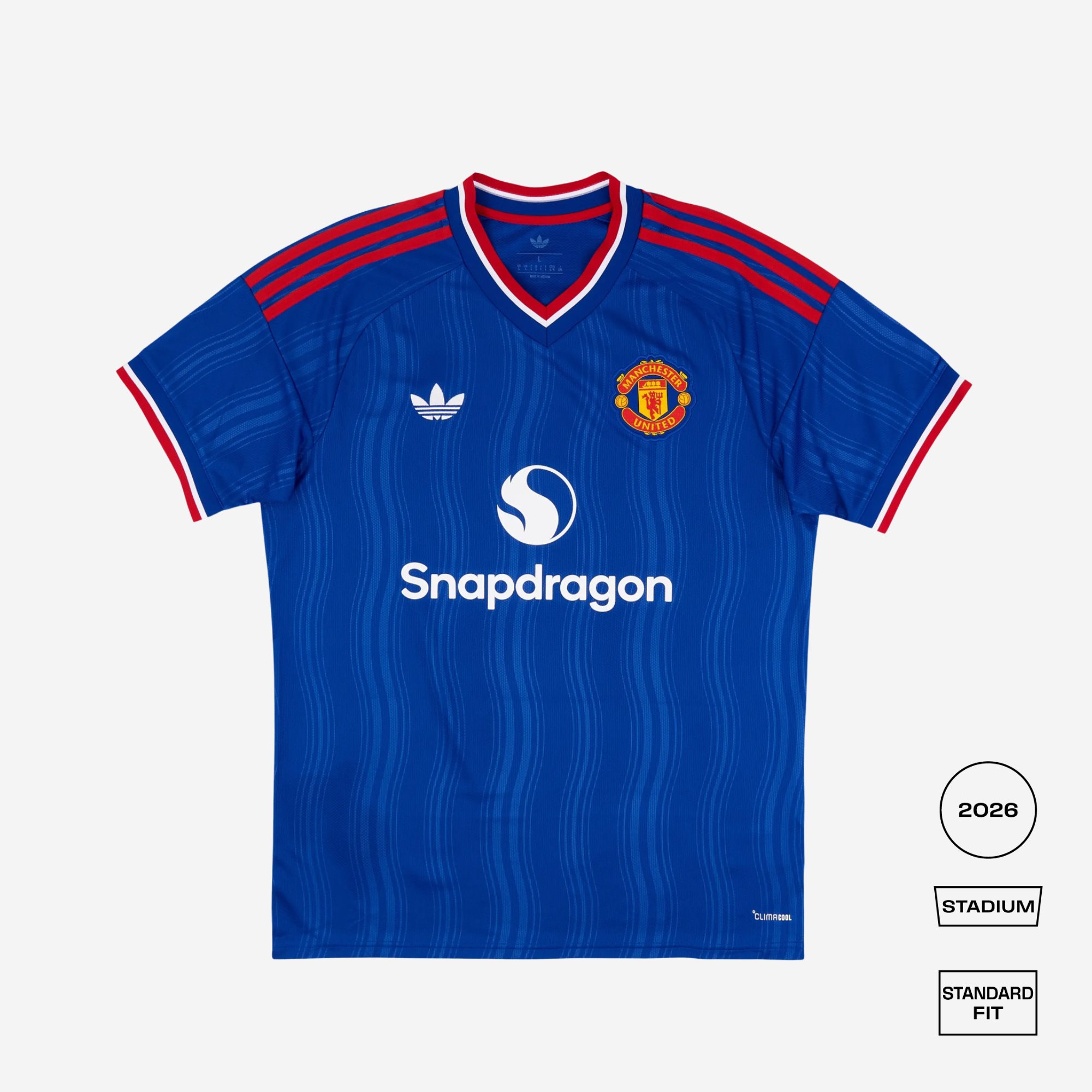 A blue Manchester United football jersey by Adidas, featuring red shoulder stripes, a white Snapdragon sponsor logo, and the club crest on the chest, displayed on a light gray background with fit labels.
