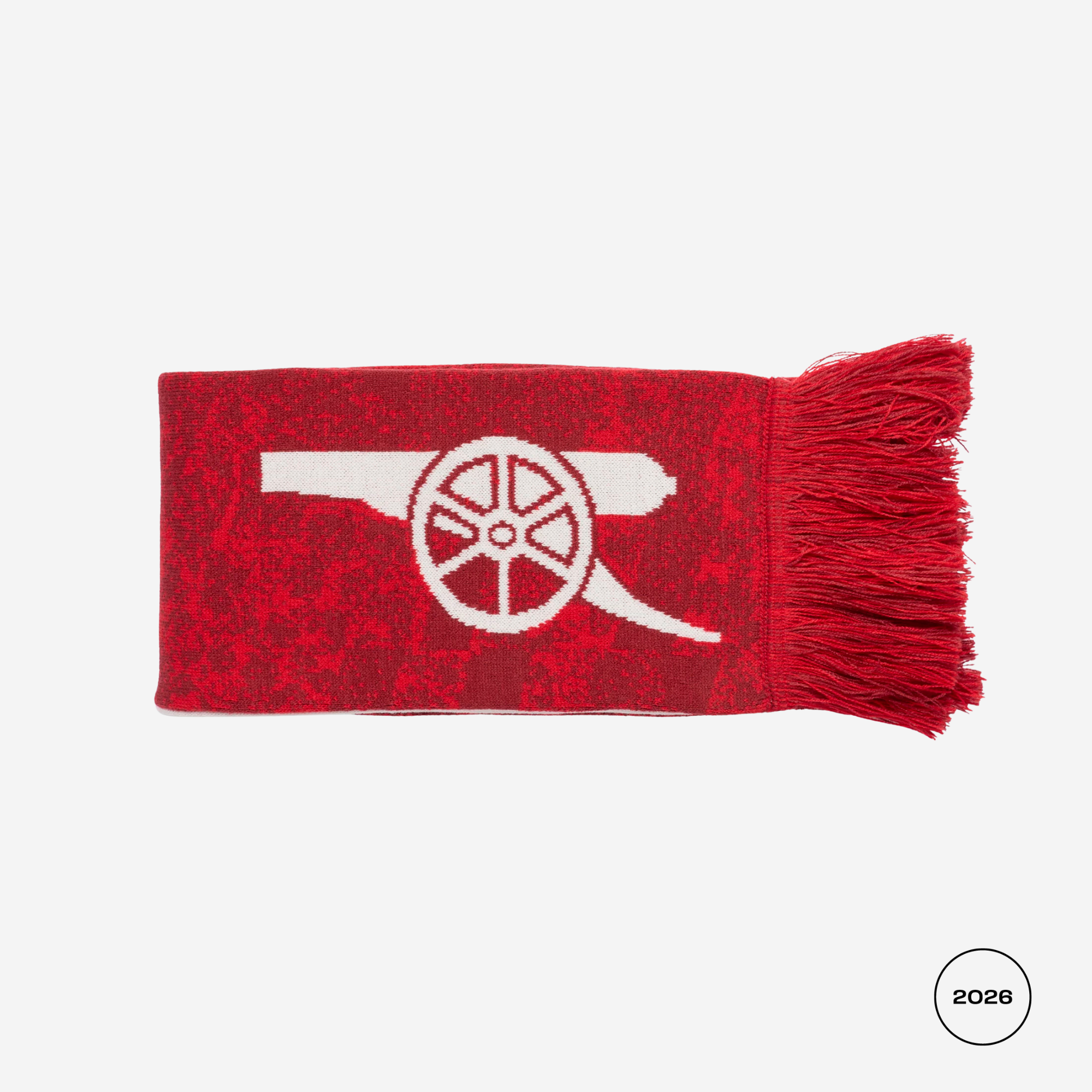 A red knit scarf with a white Arsenal cannon logo and fringed ends, shown flat against a light gray background.